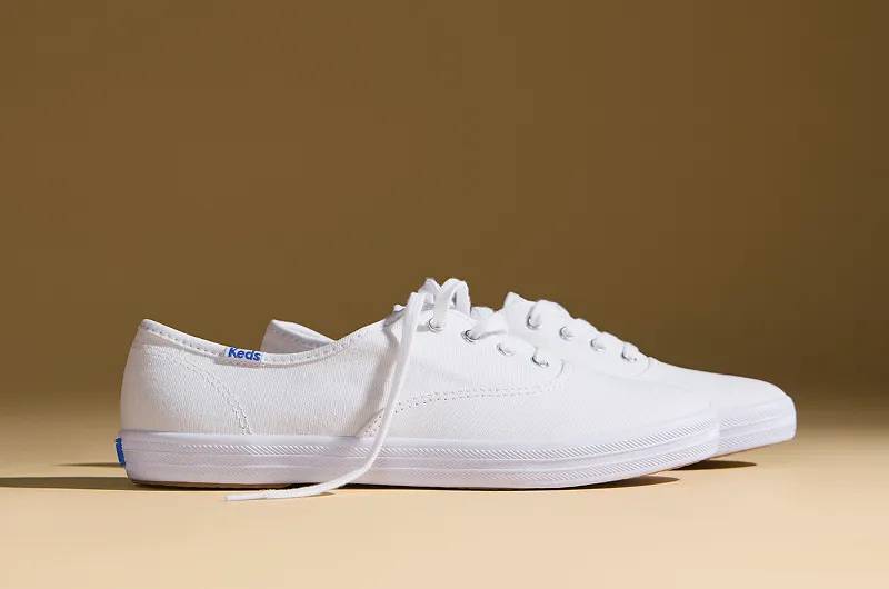 A side view of the Keds Champion Canvas Lace-Up Sneakers in white.