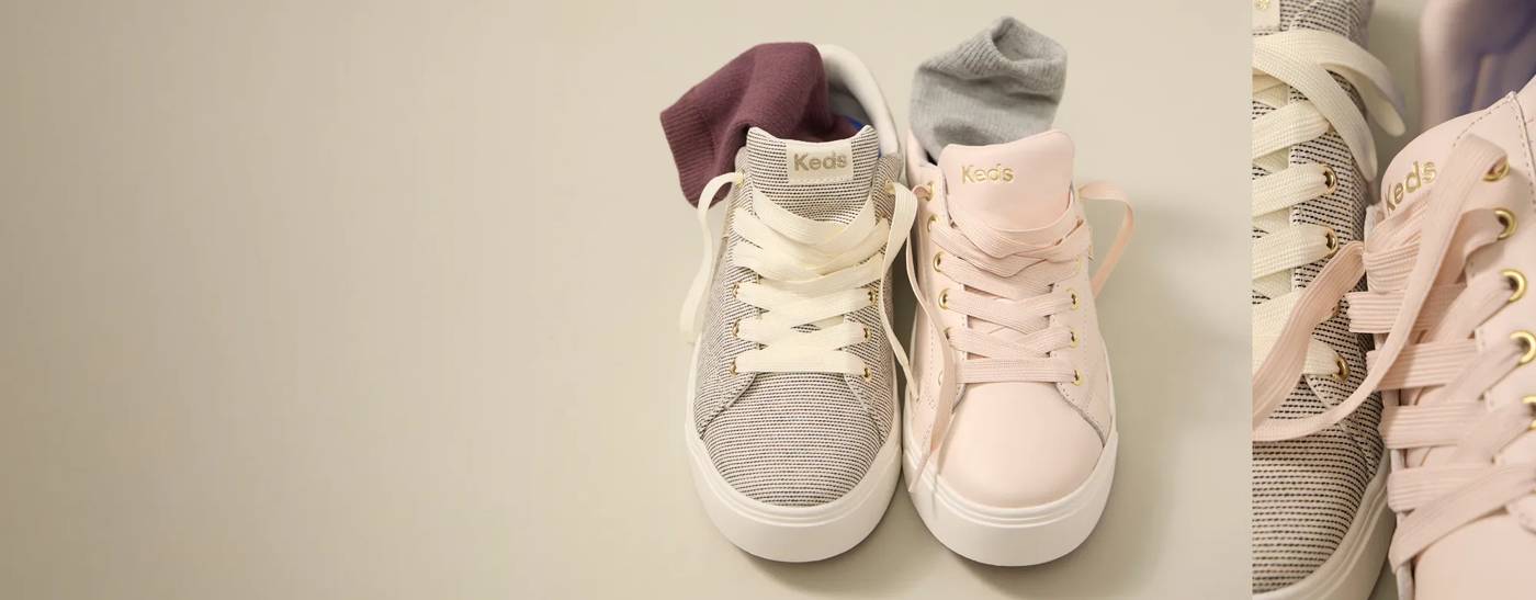 The Park Lace-Up Sneaker in seed stripe and the Park Suede Lace-Up Sneaker in blush shown together with the laces untied and with cozy socks seen sticking out of both sneakers.