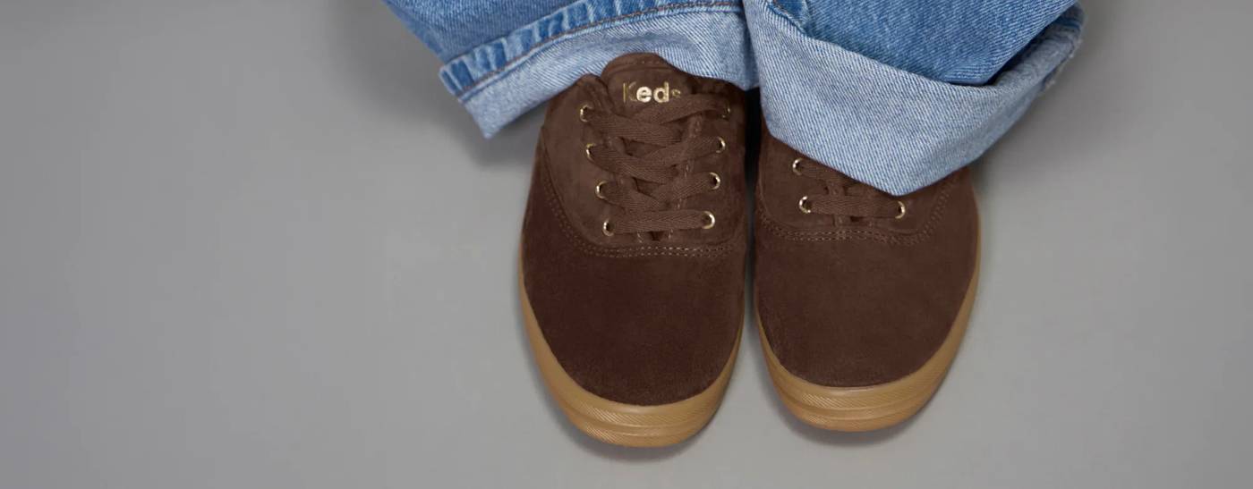 The Keds Champion Luxe Suede Lace-Up in Chocolate paired with cuffed baggy jeans.